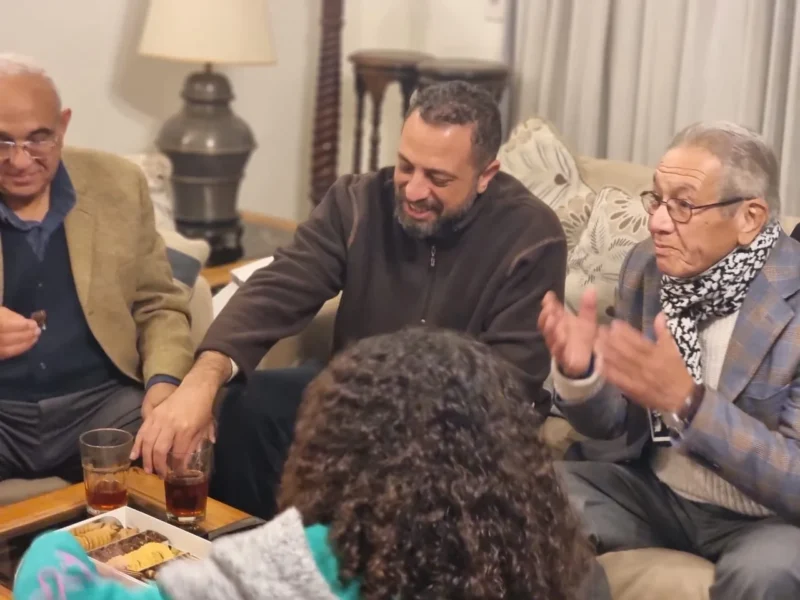 Kamal Ruhayyim speaking with family members during an evening gathering at home