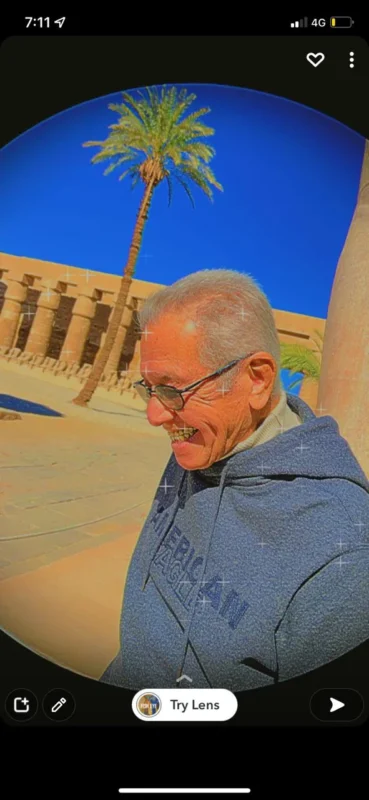 لقطة لكمال رُحيّم مبتسمًا في مكان أثري، مأخوذة من شاشة هاتف وتتضمن مؤثرات تصوير.