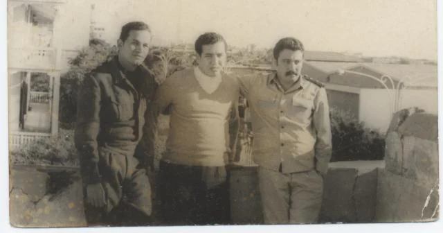 Photographie en noir et blanc de trois hommes debout ensemble ; date non renseignée.