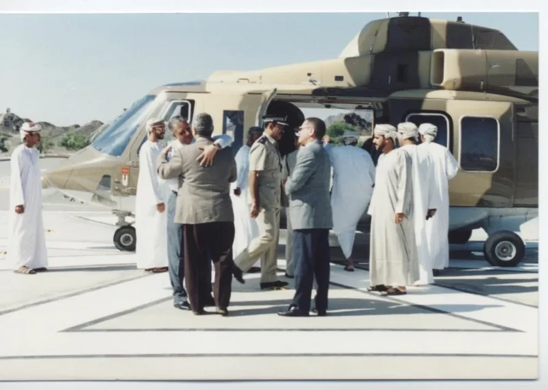 Kamal Ruhayyim mit einer offiziellen Delegation neben einem Hubschrauber